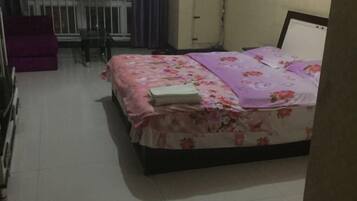Una camera da letto con un letto, una sedia e un divano viola.