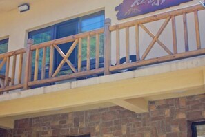 Ein Balkon mit Holzgeländern und einer Steinmauer darunter.