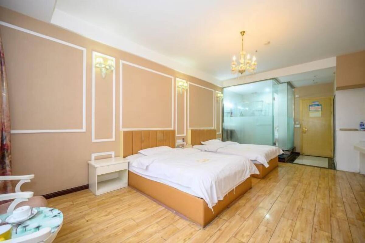 Una habitación de hotel con dos camas, un escritorio pequeño y una silla.