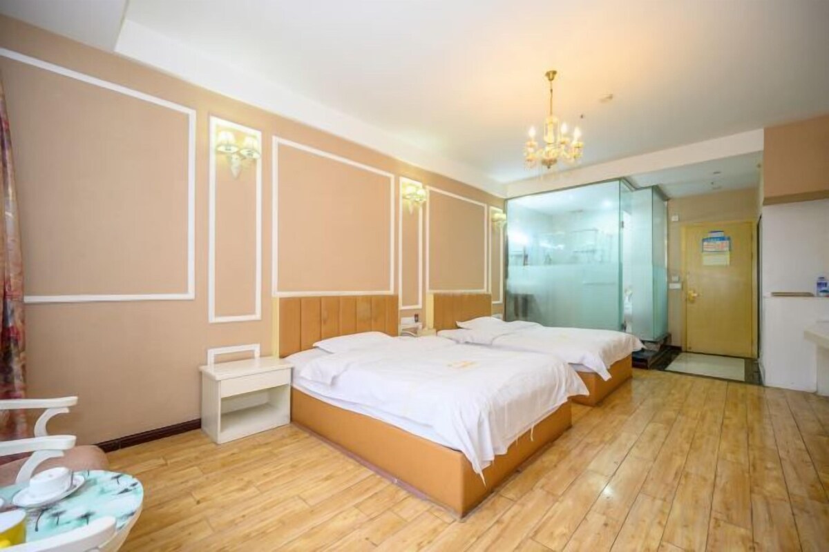 A hotel room with a large bed, bedside tables, a chair, and a mirror.