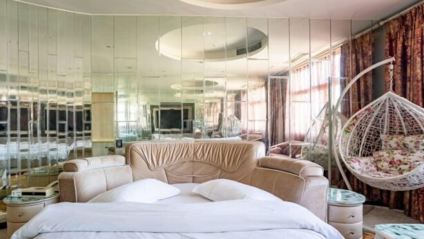 A modern hotel room with a large bed, a hanging chair, and a glass wall. - Concept hotel (Ziyang)