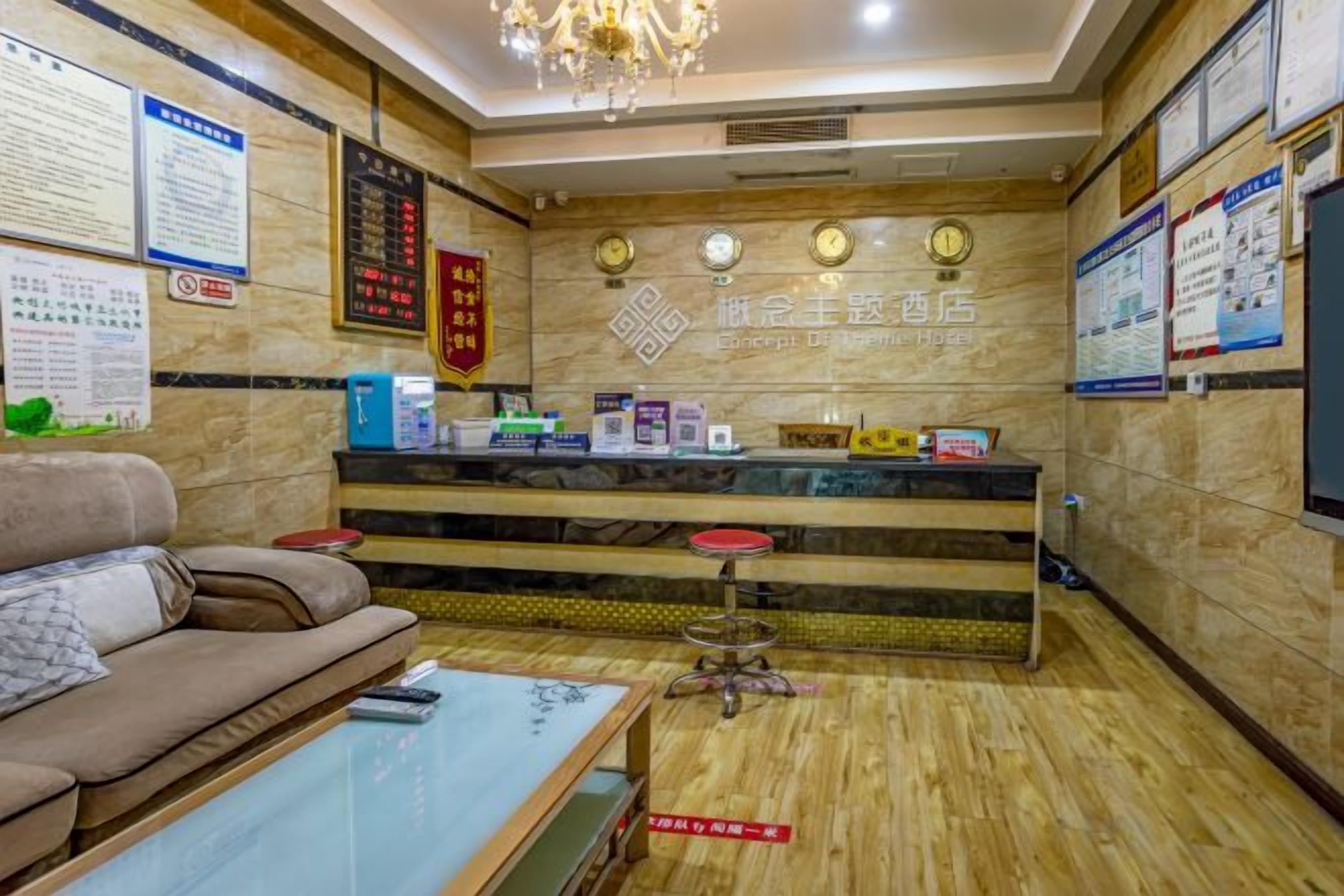 A reception area with a reception desk, a sofa, a coffee table, and a chandelier.