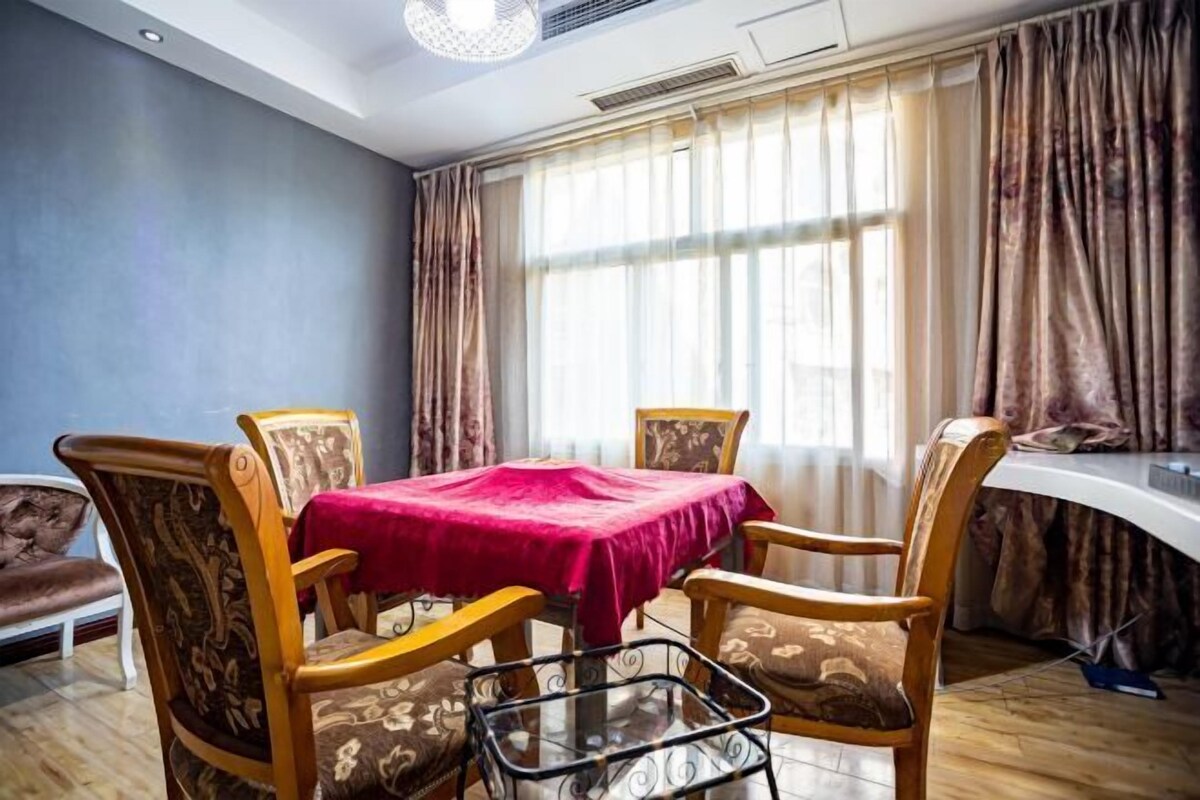 A dining area with a table set for four, surrounded by patterned chairs.