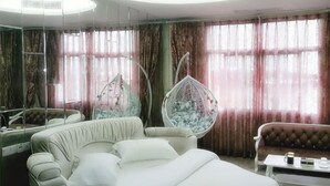 A room with a bed, a sofa, a hanging chair, and a coffee table. - Concept hotel (Ziyang)