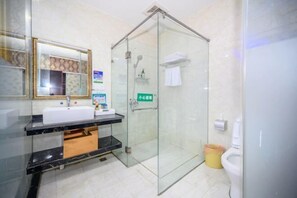 A modern bathroom with a glass-enclosed shower, a vanity with a mirror, and a toilet.