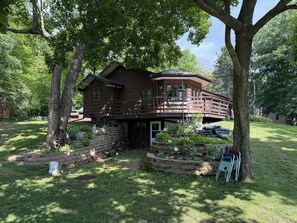 A two-story house with a balcony and a covered patio area. - "Villa Lago" Charming 4 bedroom 3 bath Farm Island Lake home with 3 fire places (Aitkin)