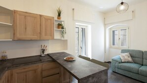 Une cuisine moderne avec des meubles en bois, un îlot central et un coin repas agrémenté d’un canapé.