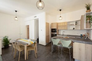 Eine moderne Küche mit Holzausstattung, einer Granitarbeitsplatte und zwei Pendelleuchten.