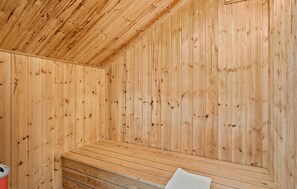 Una sauna de madera con bancos y un banco con una toalla.