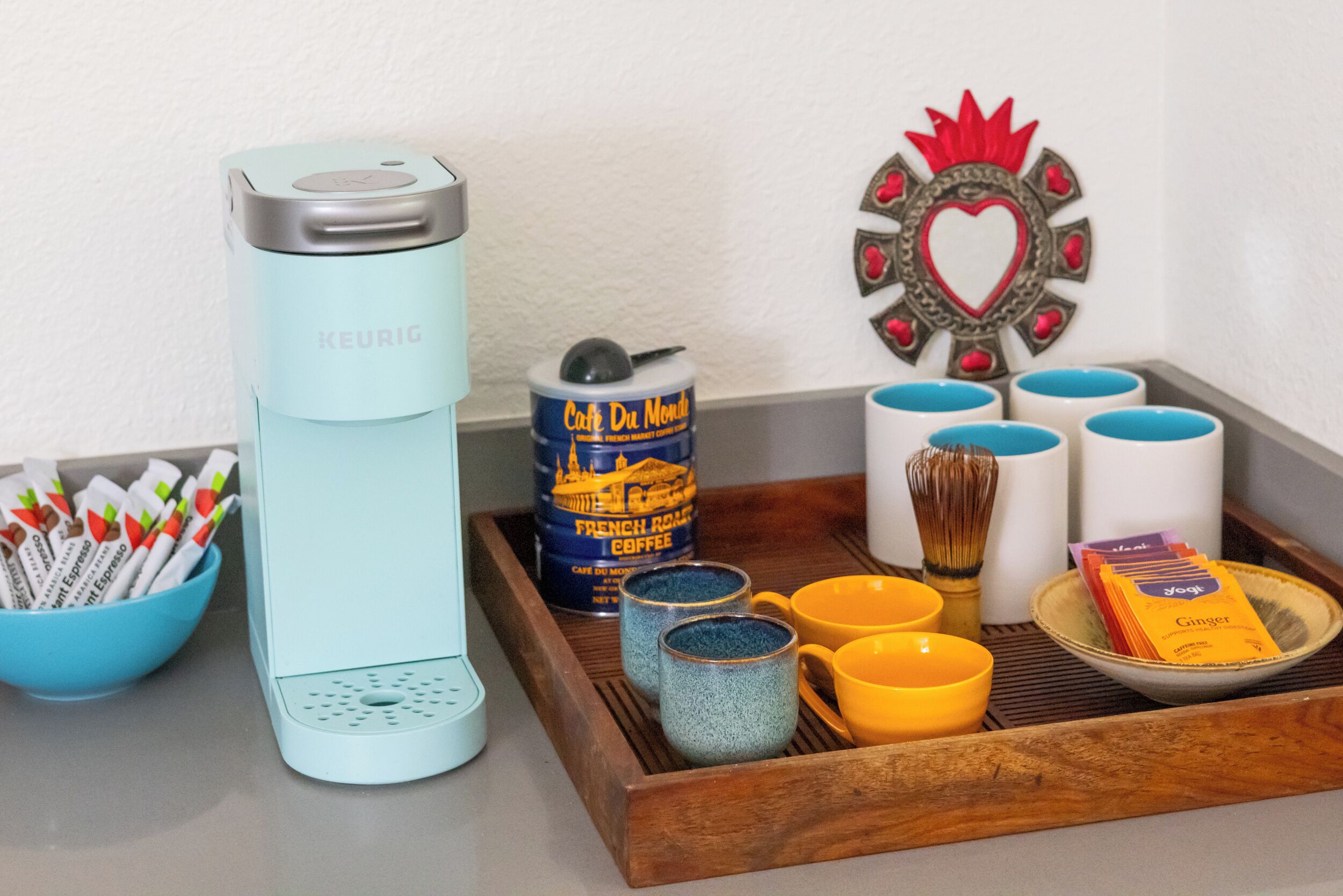 Een koffiezetapparaat, een cafetière en een dienblad met bekers en een kommetje bestek.