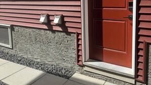 Eine rote Tür mit Briefkasten und einem Fenster darüber.