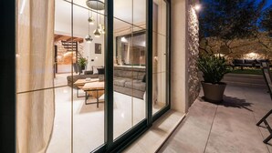 A modern house with a glass wall, a dining area, and a stone exterior. - Luxurious home in Poljaci (Poljaci)