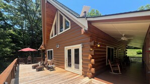 A wooden deck with outdoor furniture and a covered area.