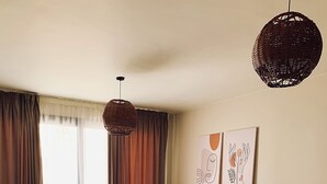Una sala de estar con un sofá, una mesa redonda de centro y una mesa de comedor con sillas.