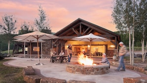 A rustic lodge with a stone fire pit and outdoor seating. - EML 7 Cloven-Hoofed (Paonia)