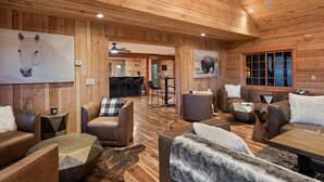 A spacious room with wooden walls and ceiling, featuring a bar area, seating with plush cushions, and artwork on the walls. - EML 7 Cloven-Hoofed (Paonia)