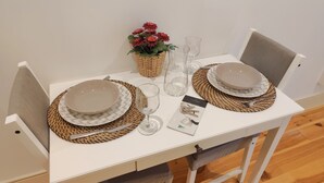 A dining table set with plates, bowls, cutlery, and a glass. - Premium Apartment Porto Downtown, With Terrace (Porto)