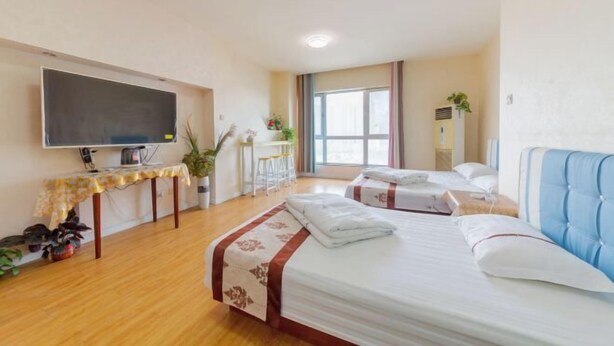 Ein Hotelzimmer mit Bett, Nachttischen, Fernseher, Schreibtisch und Fenster.