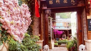 Une entrée de style chinois traditionnel, agrémentée d’une enseigne sur laquelle on peut lire « Fleurs ».