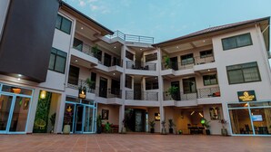 A multi-story building with a central courtyard, balconies, and various commercial spaces including a coffee lounge and a restaurant. - Maat Luxury Homes  (Santeo)