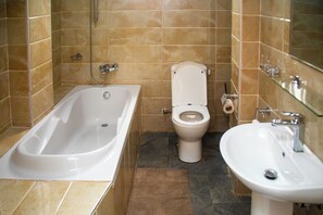A bathroom with a bathtub, toilet, and sink. - Maat Luxury Homes  (Santeo)