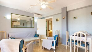 A room with a bed, a desk, chairs, a ceiling fan, a mirror, and a clock on the wall. - Awesome apartment in Torrevieja with WiFi (Torrevieja)