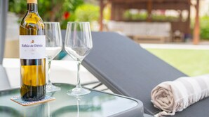 A bottle of Bahía de Dénia wine on a table with two empty glasses. - Villa Kernow - comfortable 3 bedroom villa (Moraira)