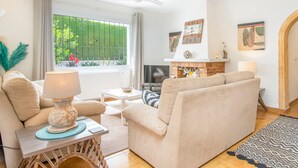 A living room with a sofa, a table with a lamp, a TV, and a fireplace. - Villa Kernow - comfortable 3 bedroom villa (Moraira)
