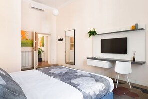 Une chambre à coucher moderne avec un lit, une télévision, un bureau et une chaise.
