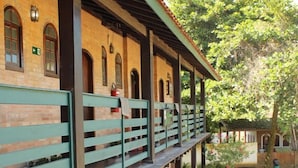 A building with a brick facade, multiple balconies, and a covered walkway. - Pousada Refúgio Manacás (Ubatuba)