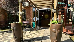 A paved walkway with two large sculptural planters. - Pousada Refúgio Manacás (Ubatuba)
