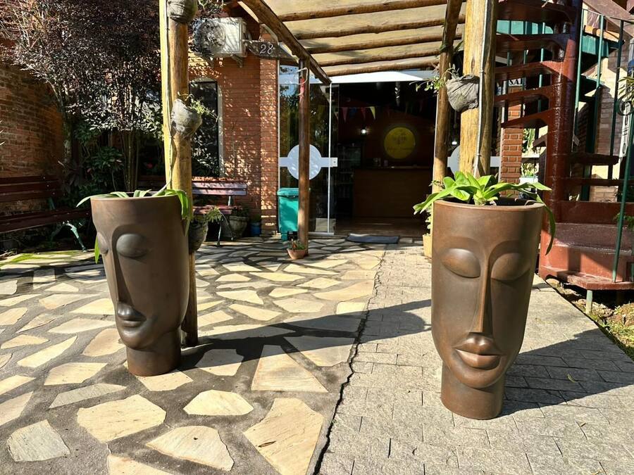 Un camí pavimentat amb dos grans jardineres escultòriques.