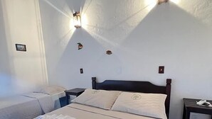 A hotel room with a bed, two bedside tables, and wall-mounted lights. - Pousada Refúgio Manacás (Ubatuba)