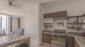 A modern kitchen with granite countertops, stainless steel appliances, and wooden cabinetry. - New Merida Retreat with Private Pool (Mérida)