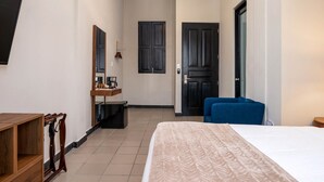 A hotel room with a bed, a desk, a chair, a wardrobe, and a television. - The Oliver Hotel - Adults Only (San Juan)