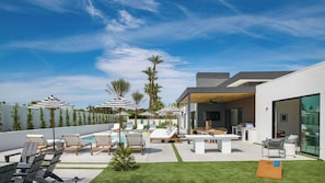 A modern outdoor patio with a pool, lounge chairs, umbrellas, and a dining area. - Polo Villa Serenity 2 Homes Sleeps 34 13 BDR (La Quinta)