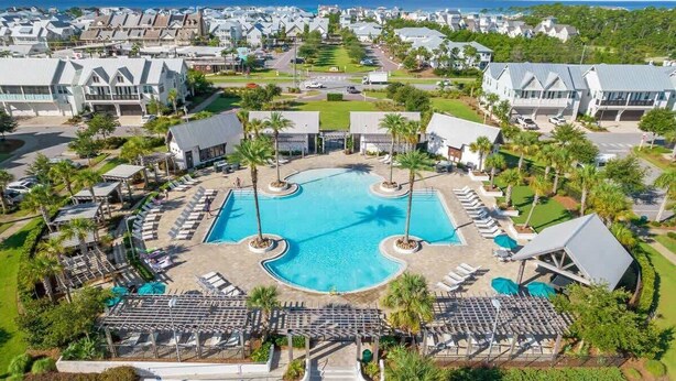 Ein Resort mit einem zentralen Schwimmbad, mehreren Liegebereichen und Blick auf den Ozean.