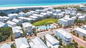 Ein Resort mit mehrstöckigen Gebäuden, einem zentralen Pool und Blick auf den Strand.