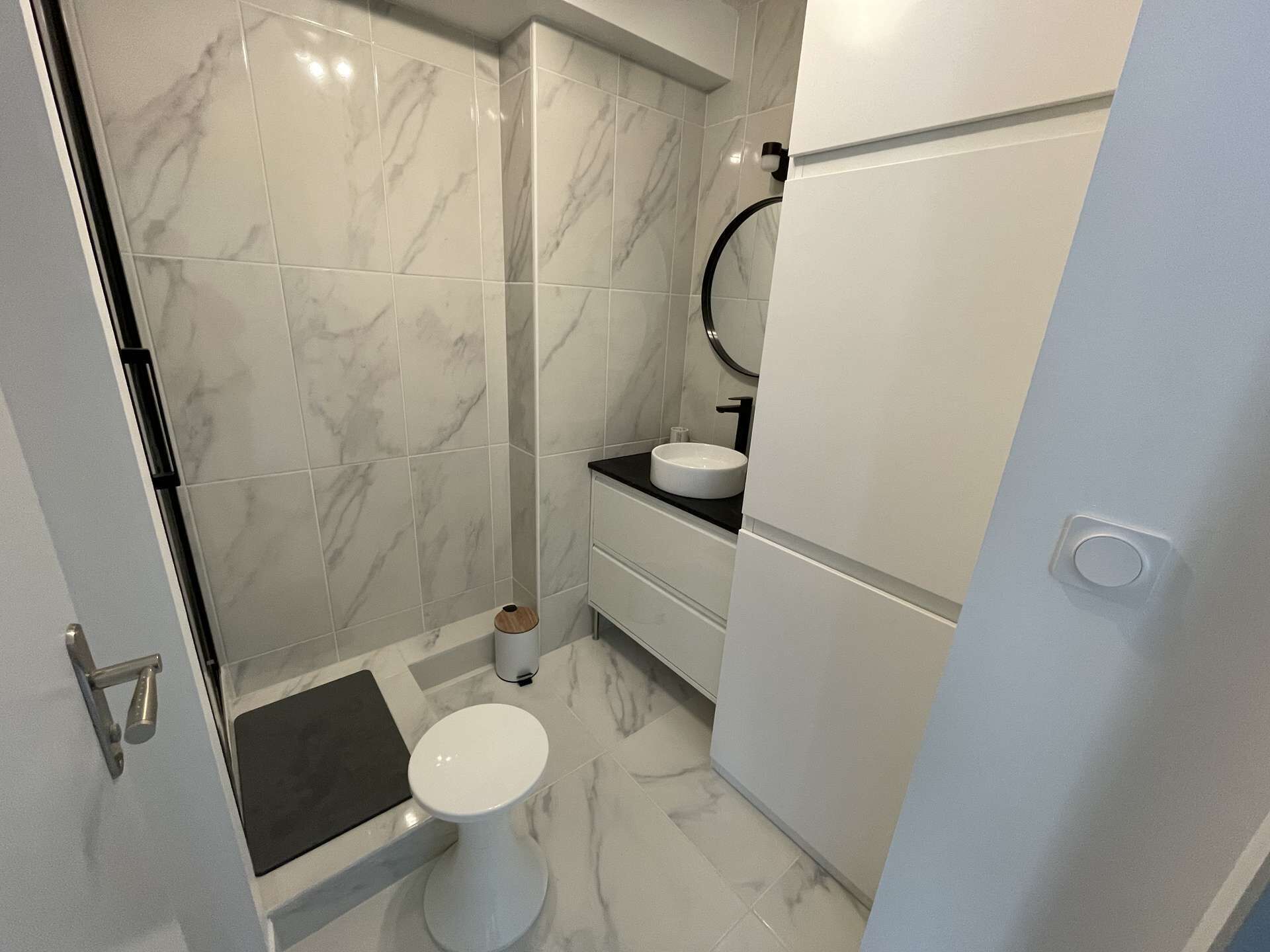 Et moderne badeværelse med bruser, toilet og vask.