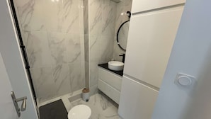 A modern bathroom with a shower, toilet, and sink. - Pornichet - Apartment near Hippodrome (PORNICHET)