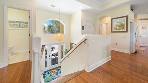 Eine Treppe mit hölzernem Geländer, einer weißen Tür und einem gerahmten Bild an der Wand.