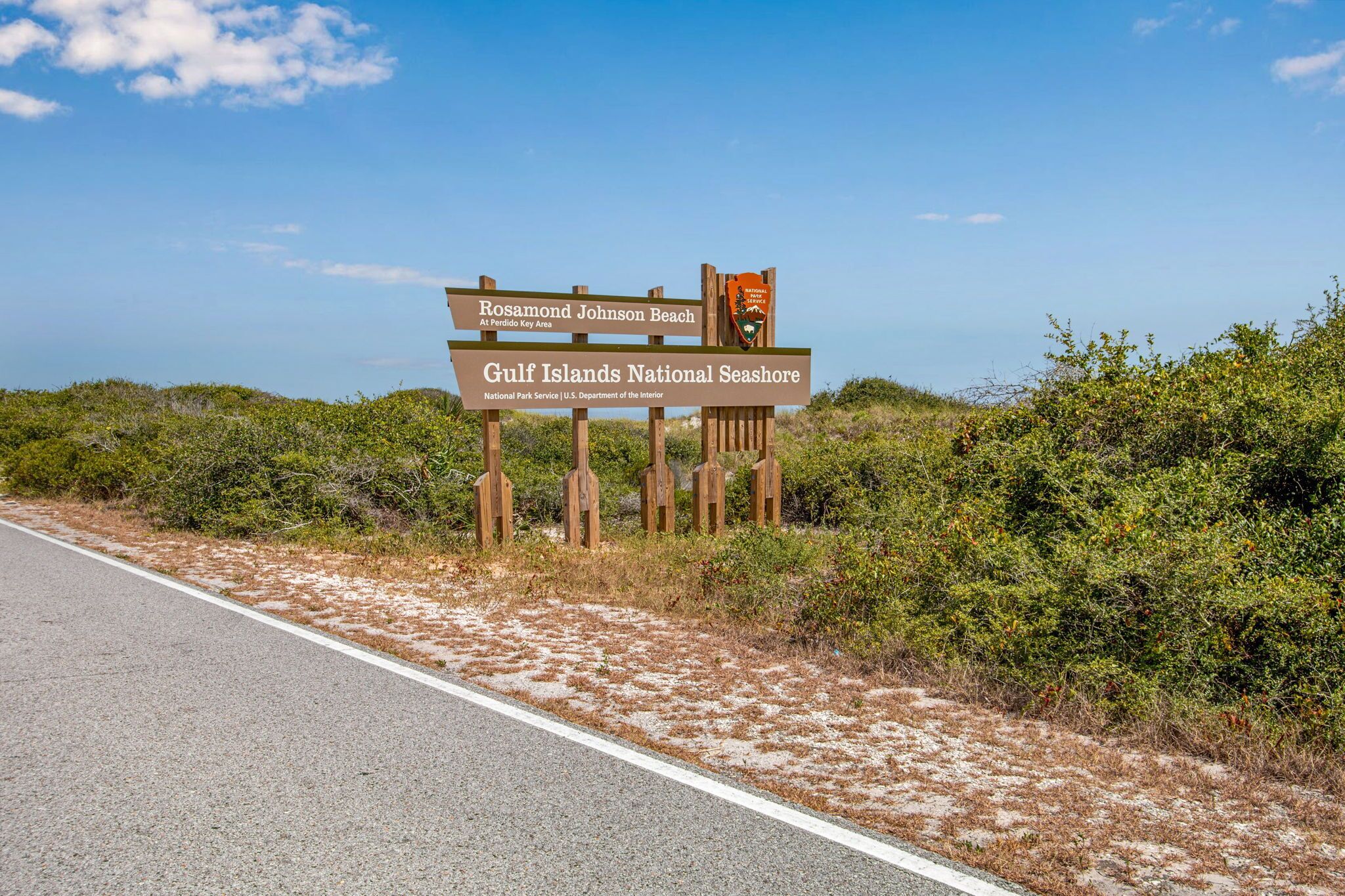 A road sign indicating Rosamond Johnson Beach and Gulf Islands National Seashore.