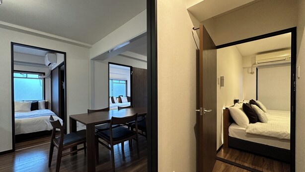 Habitación de hotel con cama, escritorio y silla. Se ve el cielo por la ventana.