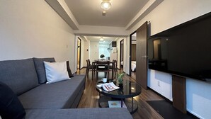 Una sala de estar moderna con un sofá, una mesa de centro y un televisor de pantalla plana.
