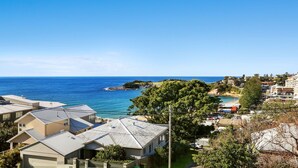 Une zone résidentielle côtière comprenant des maisons, une plage et un promontoire rocheux.