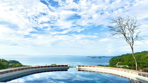 Una piscina infinita con vistas despejadas al mar y a islas distantes.