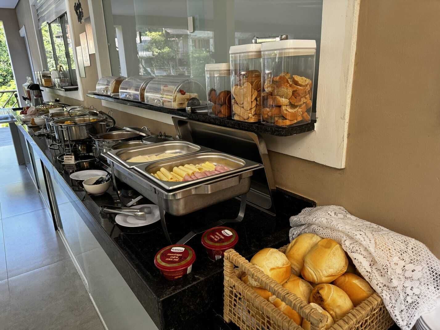 A buffet with various food items, including pasta, meats, and bread.