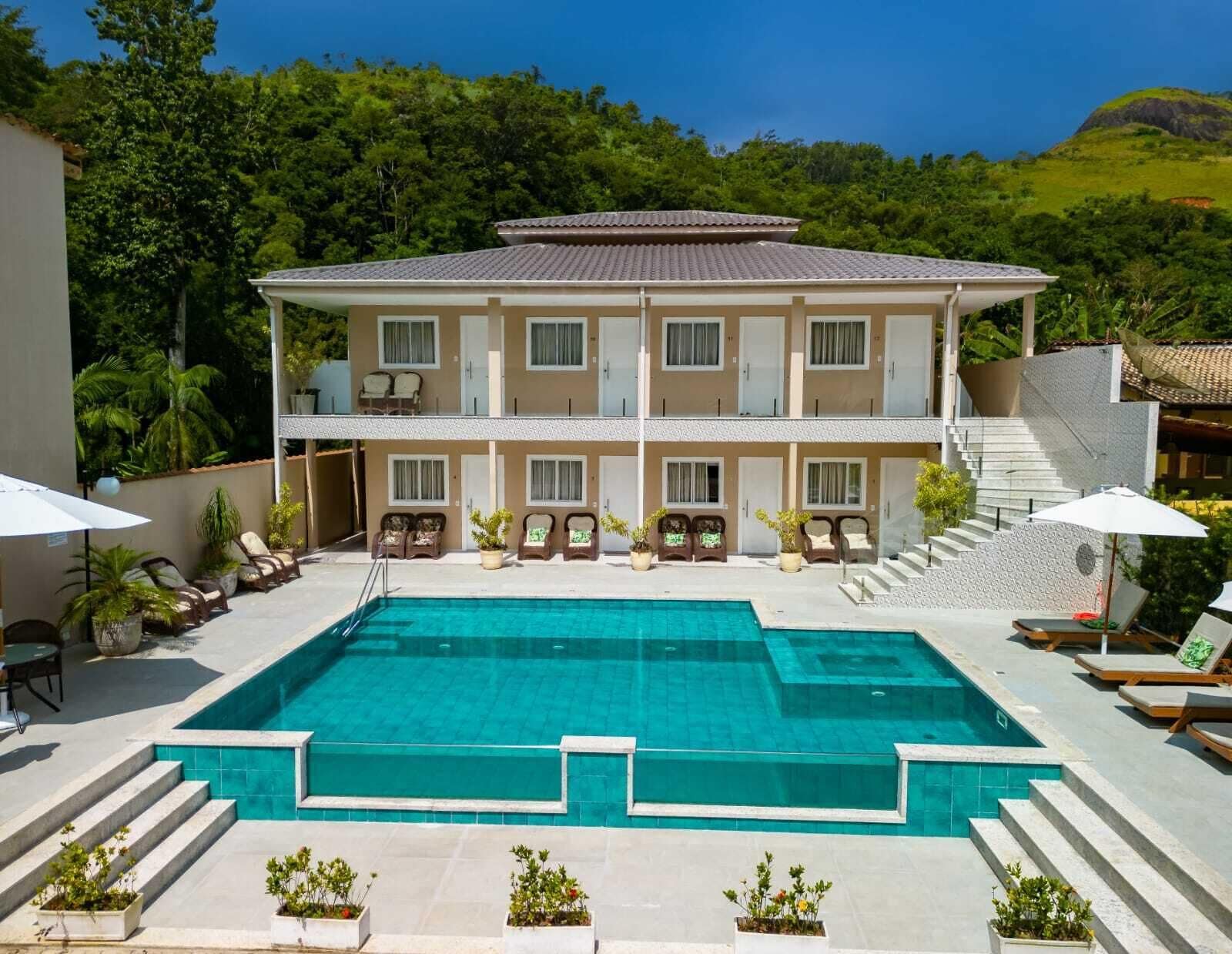 A two-story building with a swimming pool in front.