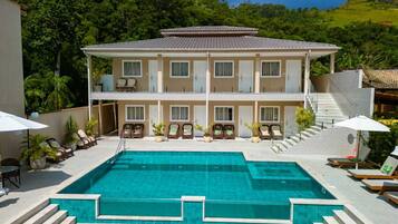 A two-story building with a swimming pool in front.