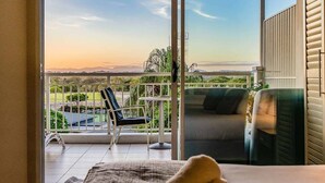 A balcony with a view of the landscape, a chair, and a sofa. - The Pool Resort Kingscliff - 1BR with Hinterland Views (5312) - Holiday Management Co. (Tweed)
